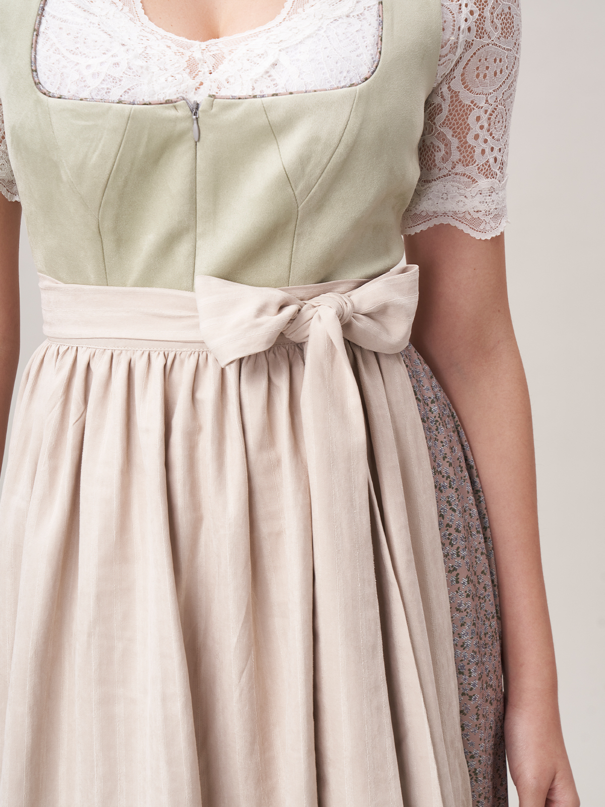 Eine Frau trägt eine grüne Sommerbluse kurzarm mit Dirndl-Rock